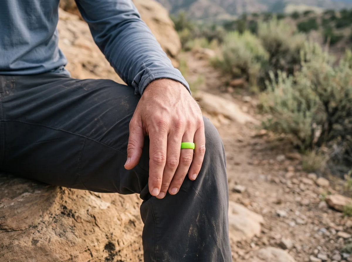 Hiker wearing a neon green silicone ring while resting on a Utah foothill trail.