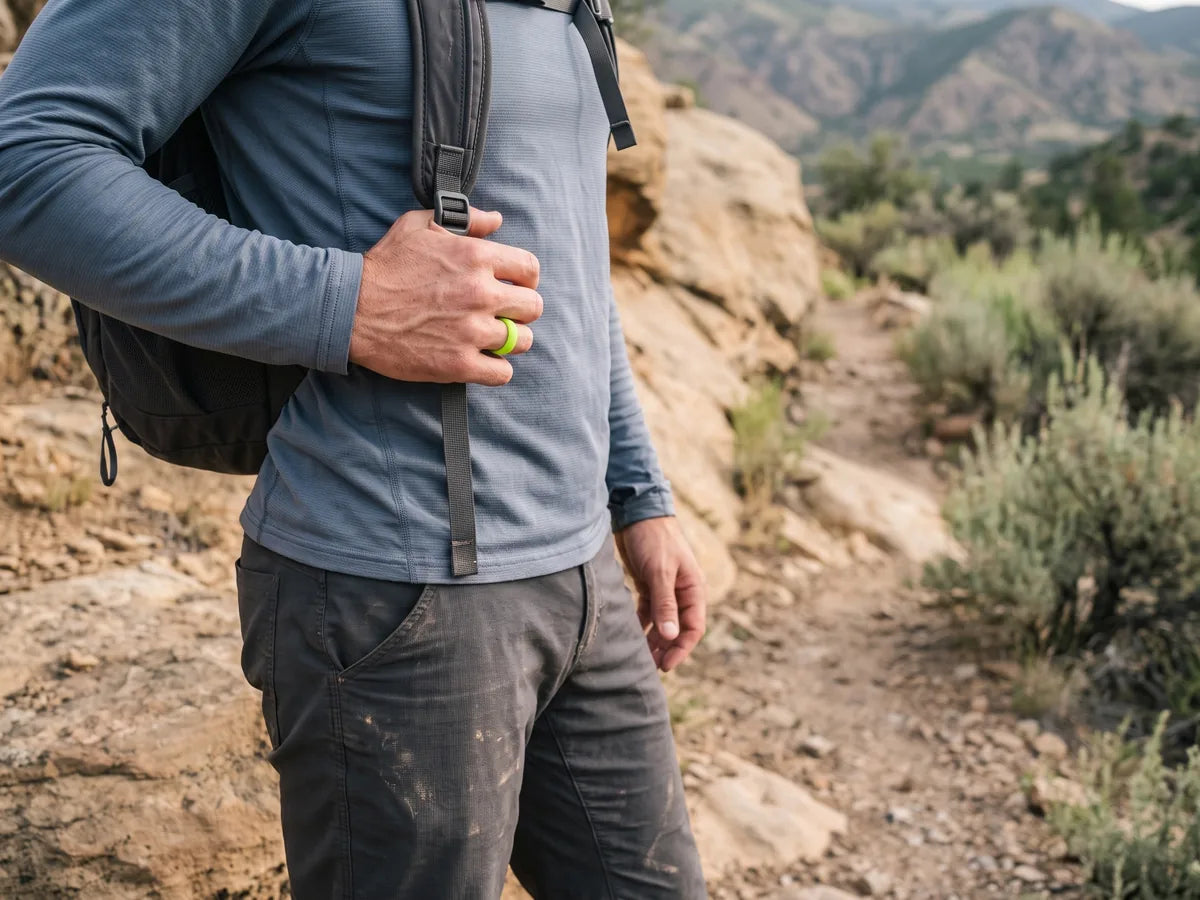 Hiker wearing a neon green silicone ring while holding a backpack strap.